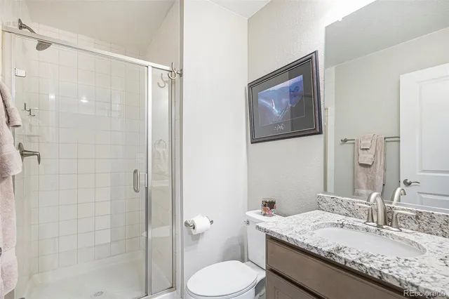 a bathroom with a granite countertop toilet sink and shower