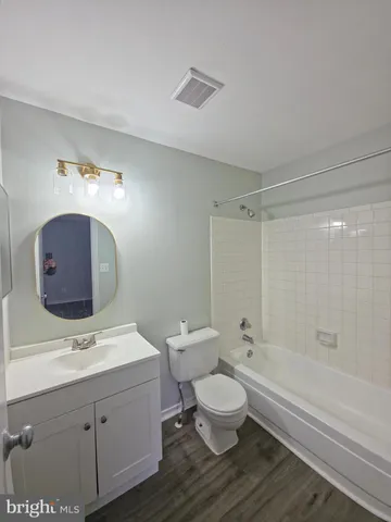 a bathroom with a toilet a sink a mirror and a bathtub