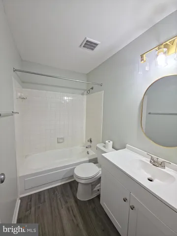 a bathroom with a double vanity sink toilet mirror and shower