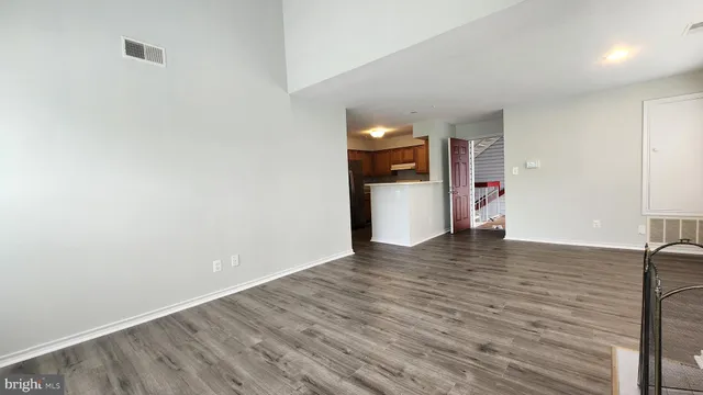a view of empty room with wooden floor