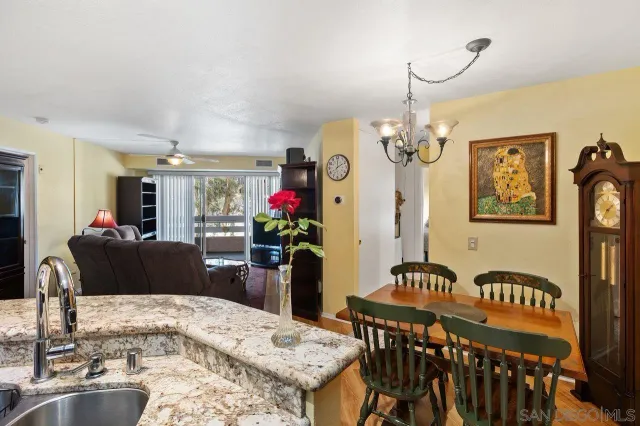 a living room with furniture a ceiling fan and a flat screen tv