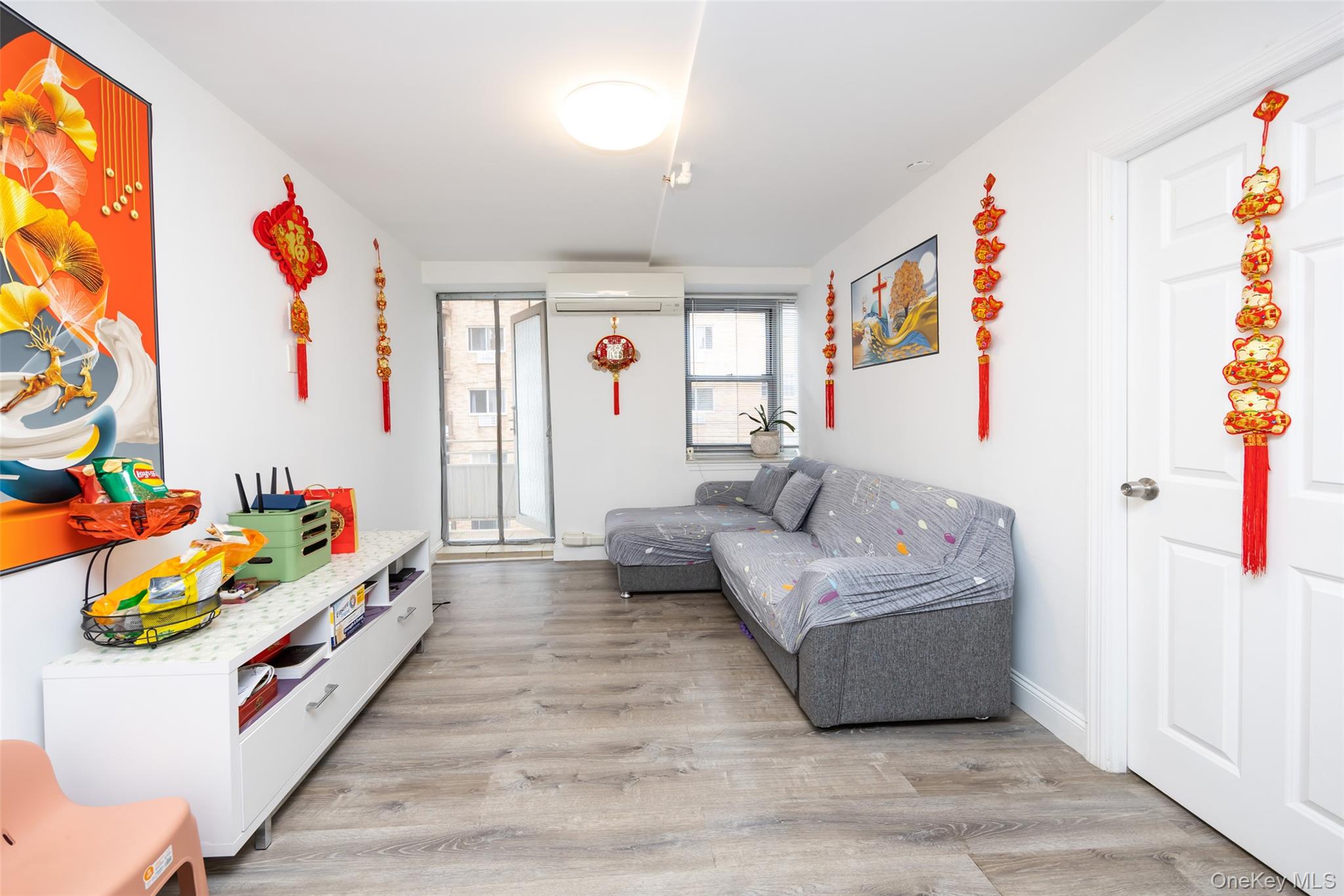 43-17 Union Street, Unit 4E Queens, NY 11355 - Photo 7 of 19 Living area with light wood-style flooring and an AC wall unit