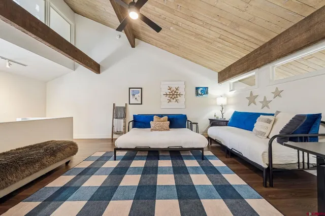 a living room with a black white checkered floor with couches and a coffee table