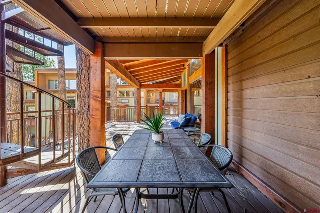 a view of a patio with table and chairs and wooden floor