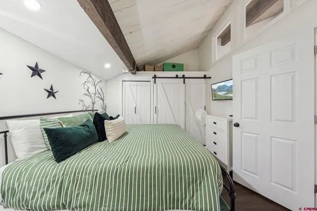 a bedroom with a bed and a painting on the wall