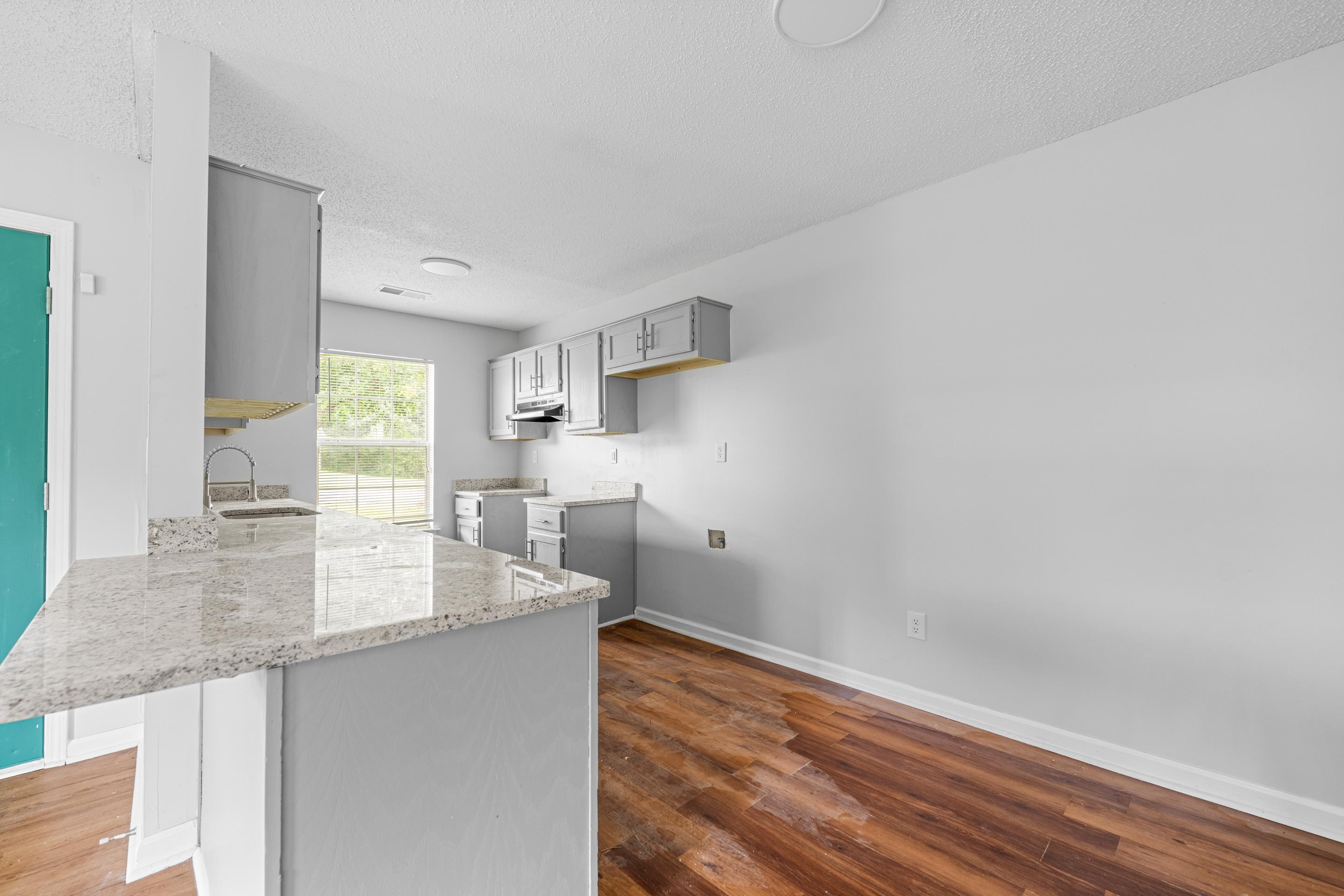 3879 Windermere Road Memphis, TN 38128 - Photo 4 of 20 a kitchen with granite countertop a sink and a wooden floor