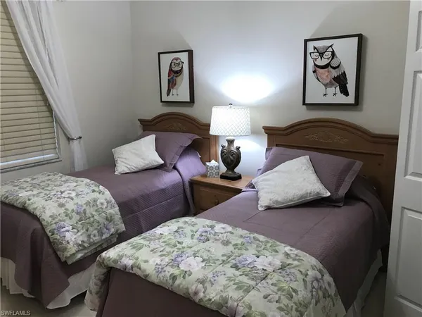 a bedroom with two beds and painting on the wall