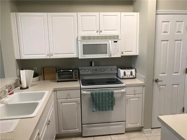 a kitchen with white cabinets and white appliances