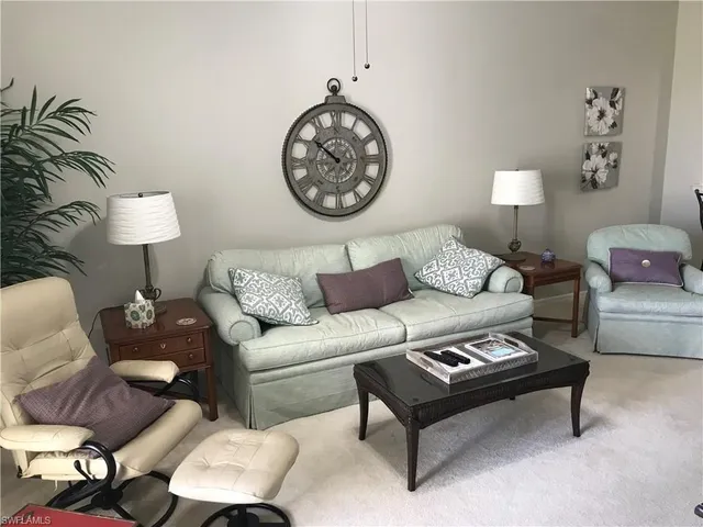a living room with furniture a lamp and a potted plant