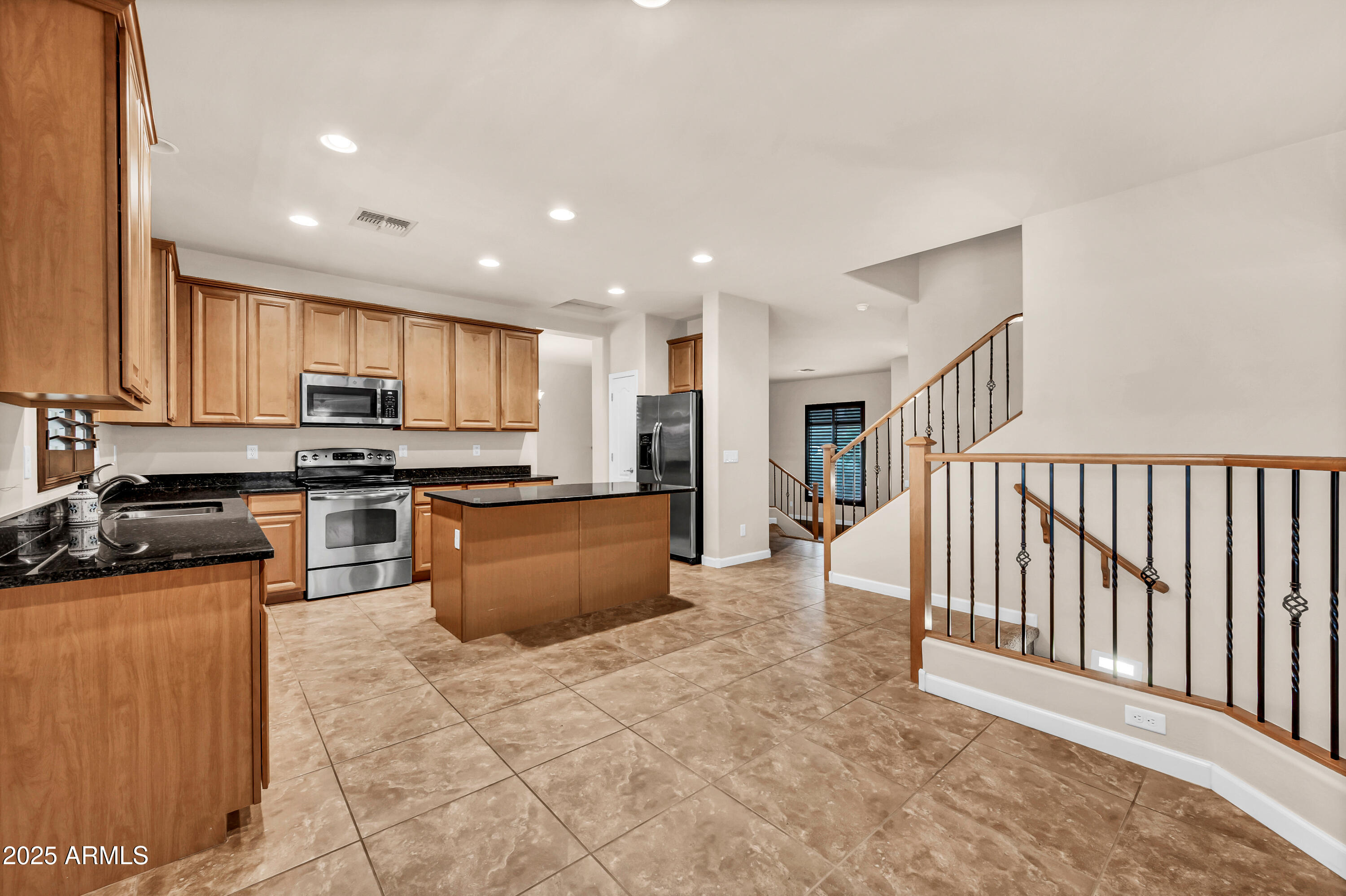 4587 South Ellesmere Street Gilbert, AZ 85297 - Photo 14 of 55 a kitchen with stainless steel appliances granite countertop a stove top oven a sink a counter top space and cabinets