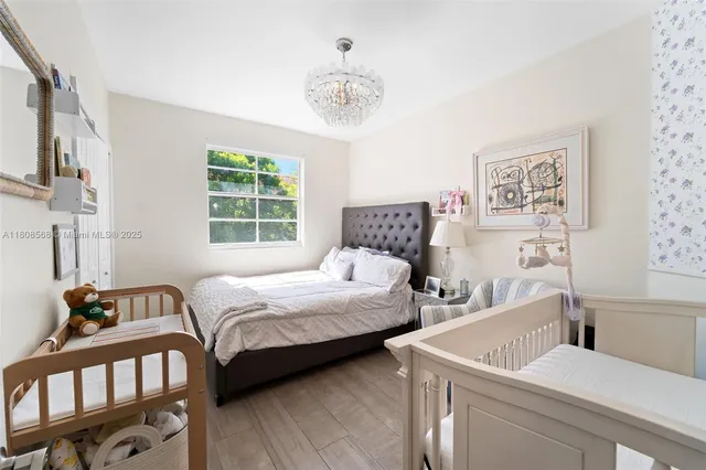 a bedroom with two beds and a chandelier