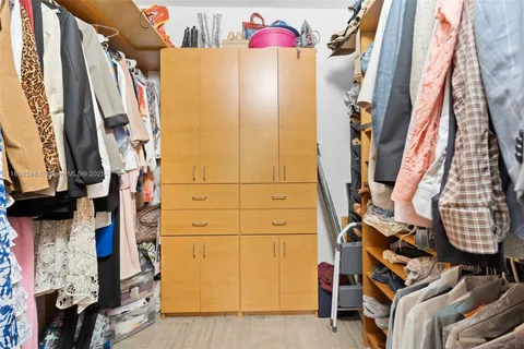 a view of walk in closet with clothes