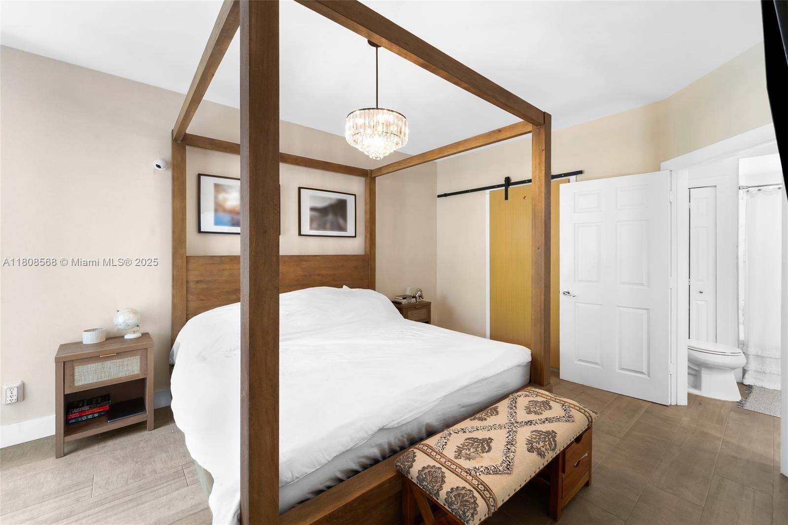 3245 Northeast 184th Street, Unit 13402 Aventura, FL 33160 - Photo 17 of 28 a bedroom with a bed a chandelier and a window