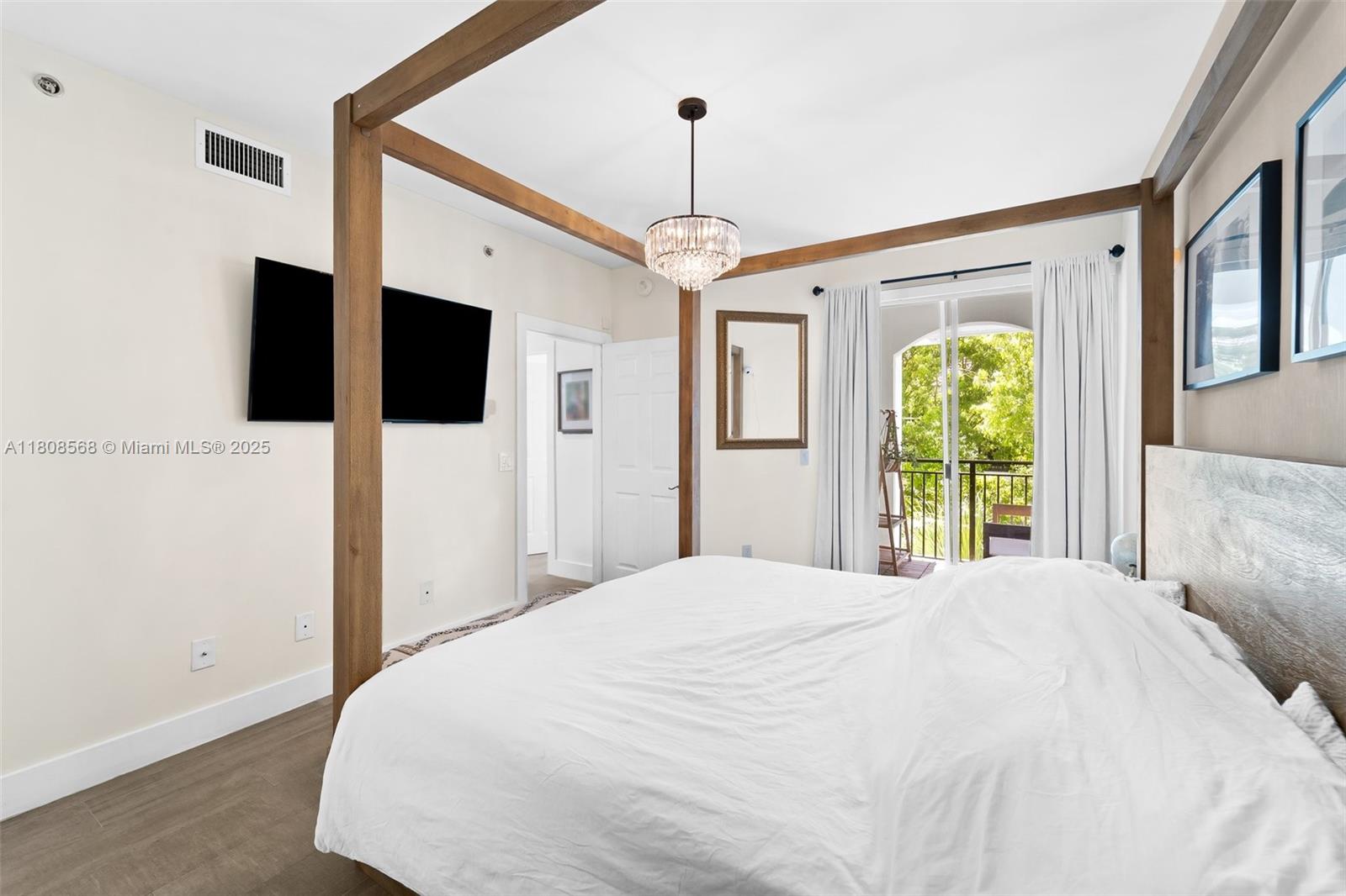 3245 Northeast 184th Street, Unit 13402 Aventura, FL 33160 - Photo 19 of 28 a bedroom with a bed and a flat screen tv