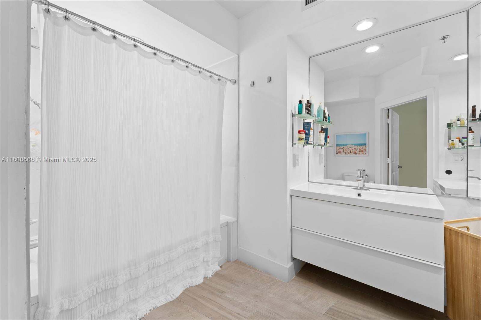 3245 Northeast 184th Street, Unit 13402 Aventura, FL 33160 - Photo 20 of 28 a bathroom with a shower sink and mirror