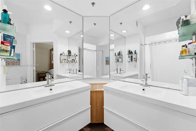 a bathroom with a sink a large mirror and shower