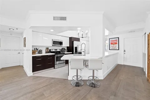 a kitchen with a sink cabinets and wooden floor