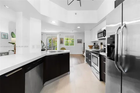 a kitchen with stainless steel appliances kitchen island granite countertop a refrigerator a sink a stove and island