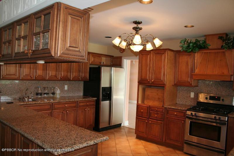 1515 Lands End Road Manalapan, FL 33462 - Photo 10 of 21 a kitchen with stainless steel appliances granite countertop a refrigerator a oven a sink dishwasher and wooden cabinets with wooden floor