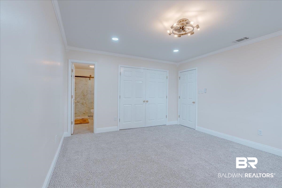 440 Dykes Road Mobile, AL 36608 - Photo 25 of 49 Unfurnished bedroom with visible vents, baseboards, carpet floors, ornamental molding, and a closet