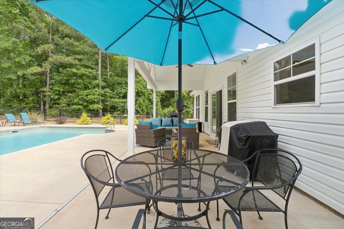 683 Teagle Road Forsyth, GA 31029 - Photo 37 of 50 a view of a swimming pool with a table and chairs under an umbrella