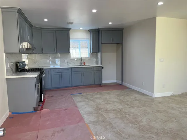 a kitchen with kitchen island granite countertop a sink stove and cabinets