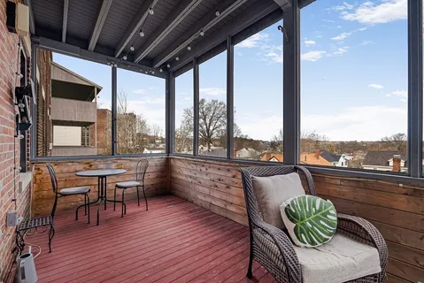 a balcony with chairs and wooden floor