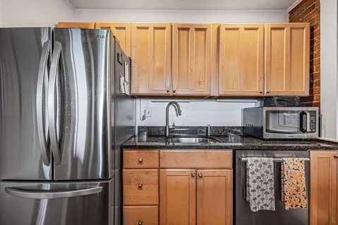 a kitchen with stainless steel appliances granite countertop a refrigerator and a stove