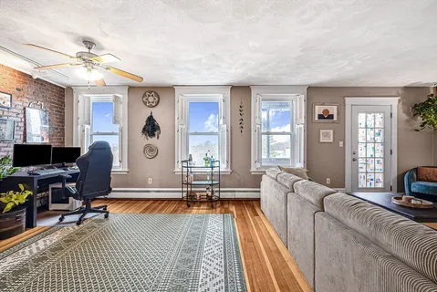 a living room with furniture a flat screen tv and a large window