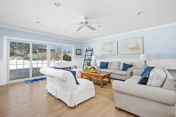 a kitchen with stainless steel appliances a refrigerator a stove a sink dishwasher and white cabinets with wooden floor