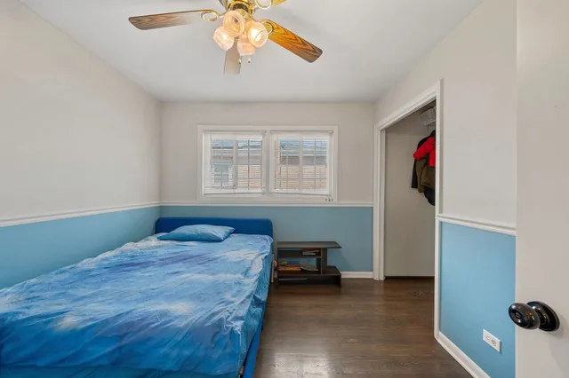 a bedroom with a bed and a ceiling fan