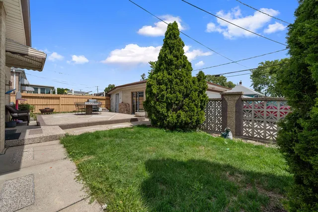 a picture of a yard with plants and a fountain