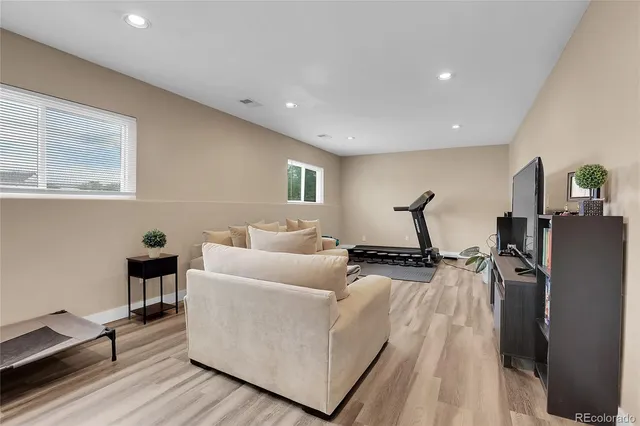 a living room with furniture and a wooden floor