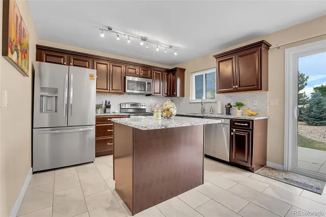 a kitchen with a refrigerator stove top oven and sink