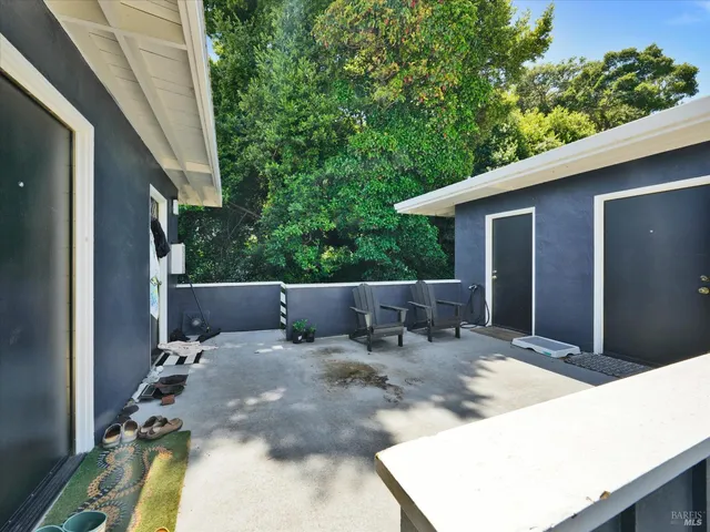 a view of a patio with table and chairs with wooden floor and fence