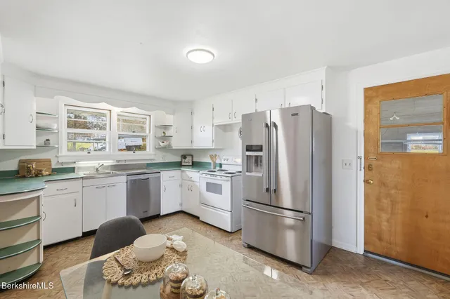 a kitchen with stainless steel appliances a refrigerator sink and cabinets