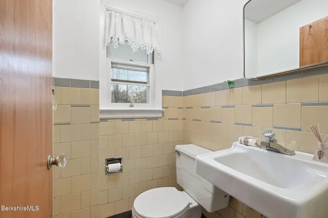 a bathroom with a sink a toilet and mirror