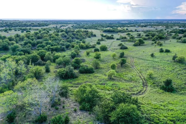 an aerial view of residential houses with outdoor space and trees