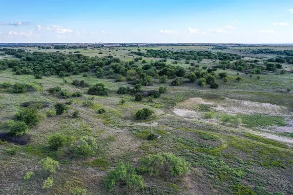 a view of a field with an oven and a forest