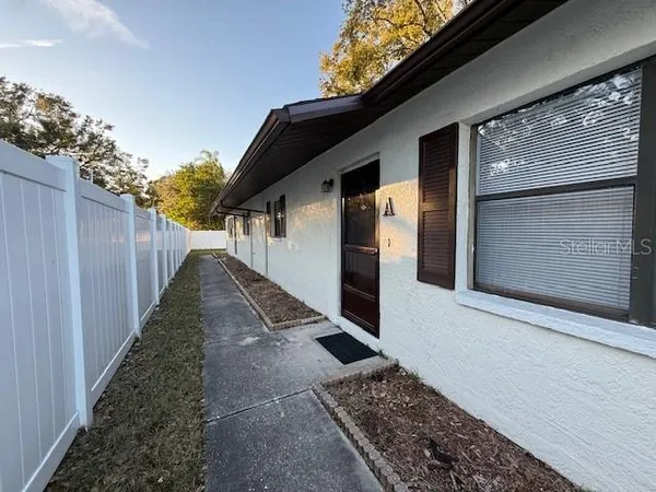 a view of a pathway of a house with wooden fence