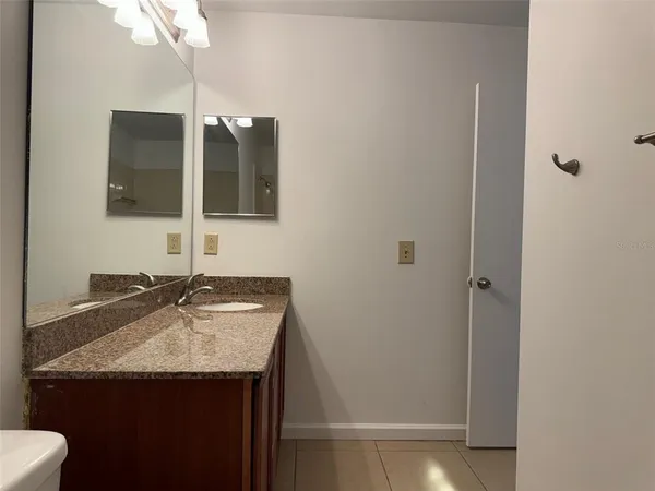 a bathroom with a granite countertop sink and a mirror