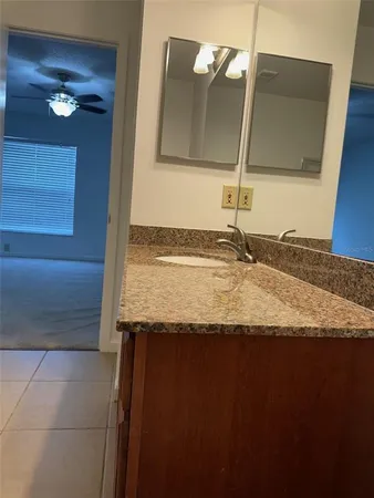 a bathroom with a granite countertop sink and a mirror