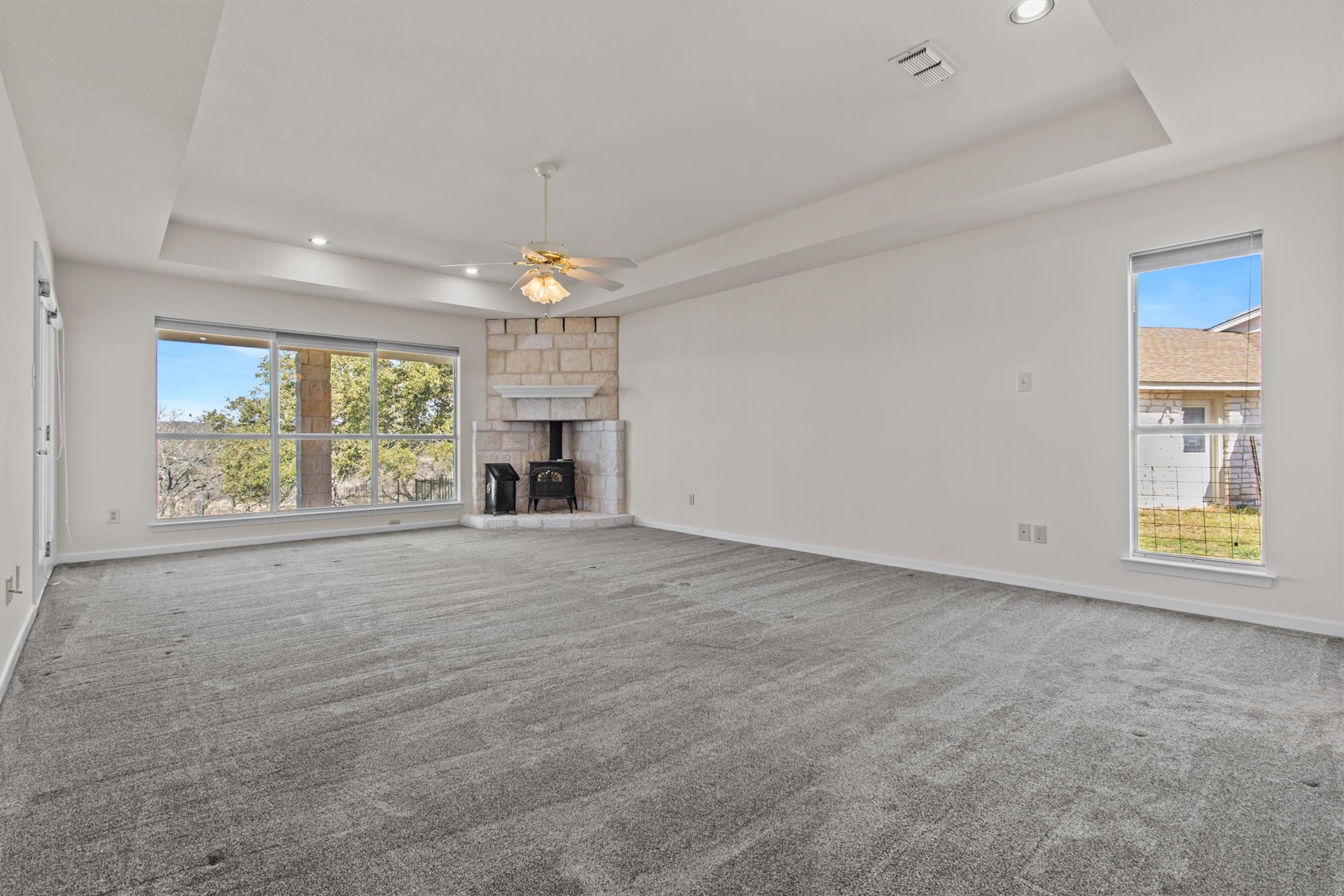 25048 River Road Spicewood, TX 78669 - Photo 12 of 33 Massive primary bedroom with wood burning stove. French doors to covered patio and Pedernales view