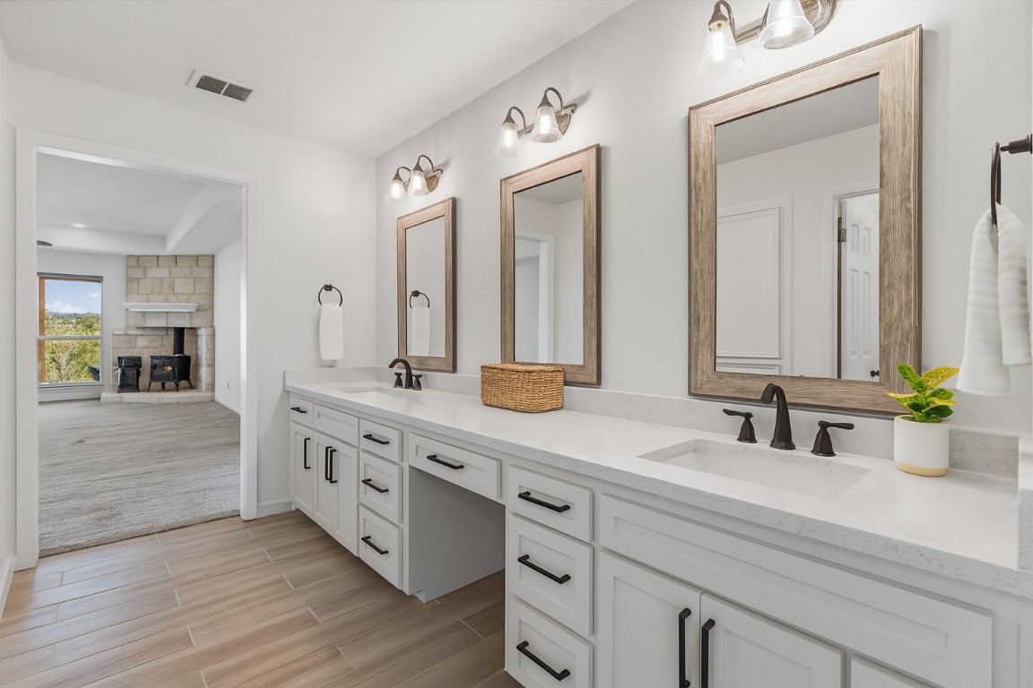 25048 River Road Spicewood, TX 78669 - Photo 13 of 33 a bathroom with double vanity sinks and a mirror