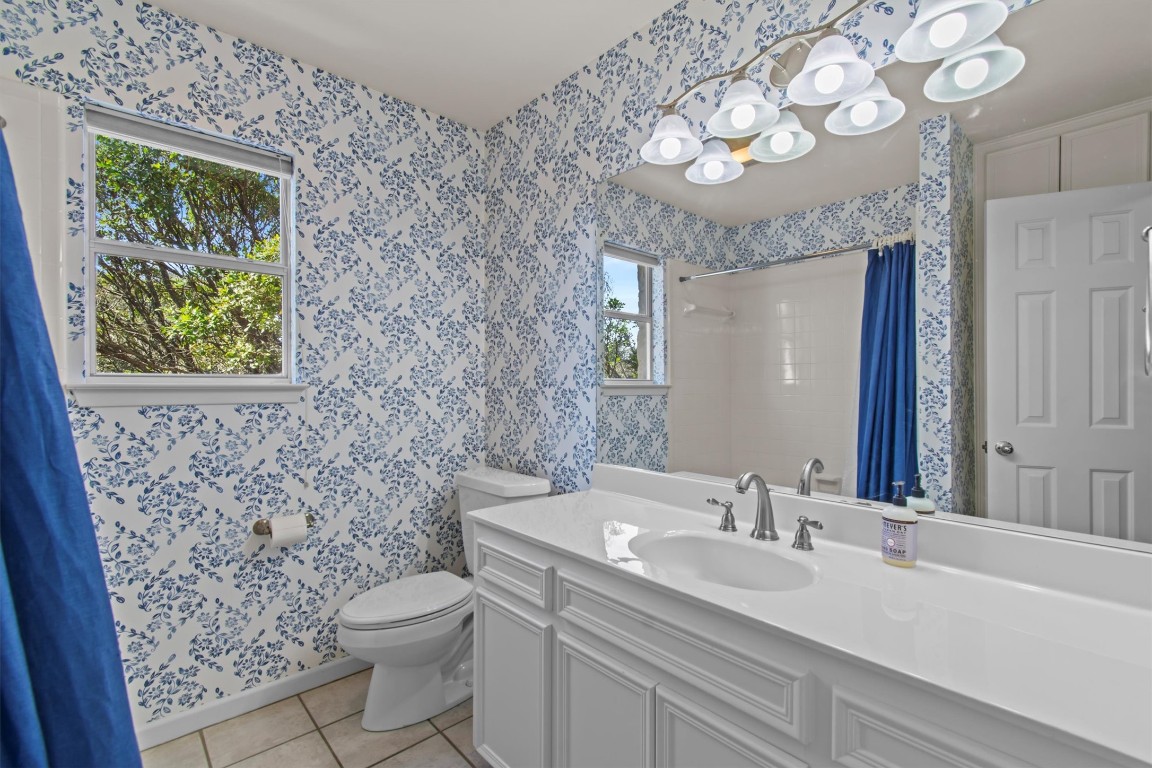 25048 River Road Spicewood, TX 78669 - Photo 17 of 33 a bathroom with a sink a toilet and a mirror