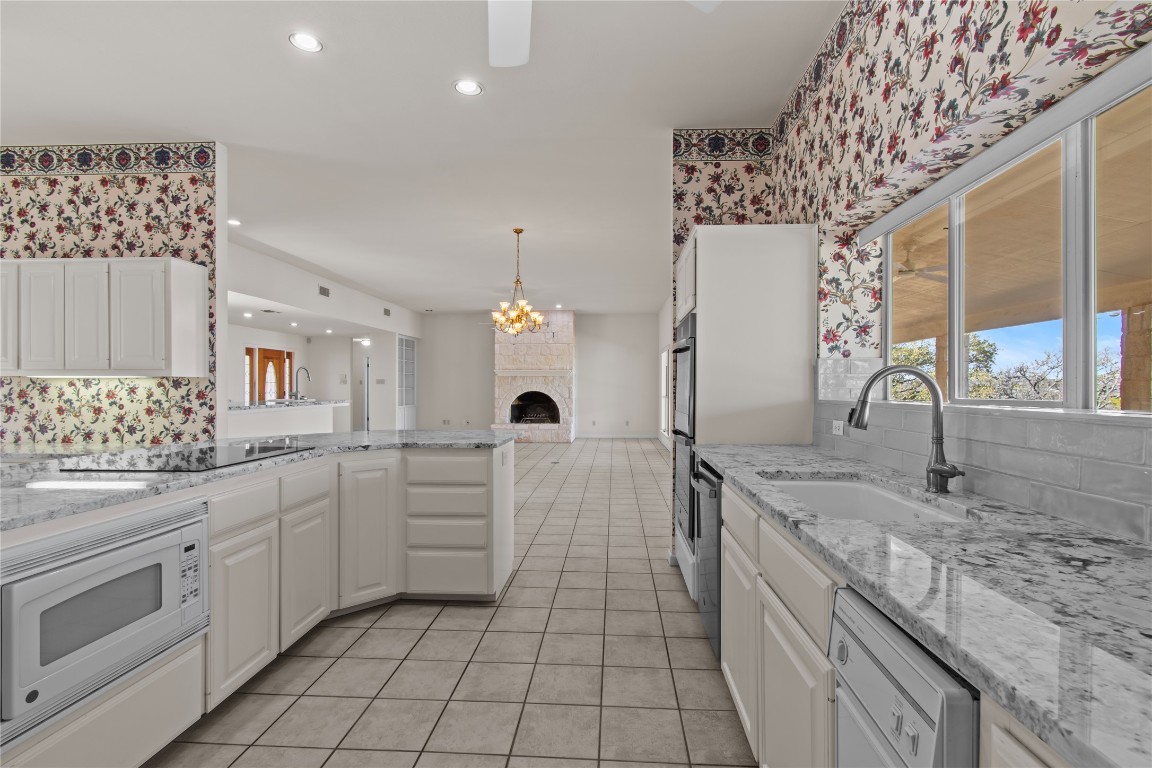 25048 River Road Spicewood, TX 78669 - Photo 6 of 33 a kitchen with a sink stove and cabinets