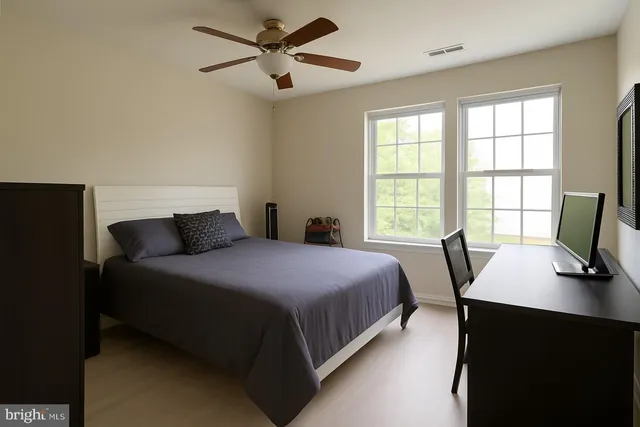 a bedroom with a bed window and a flat screen tv