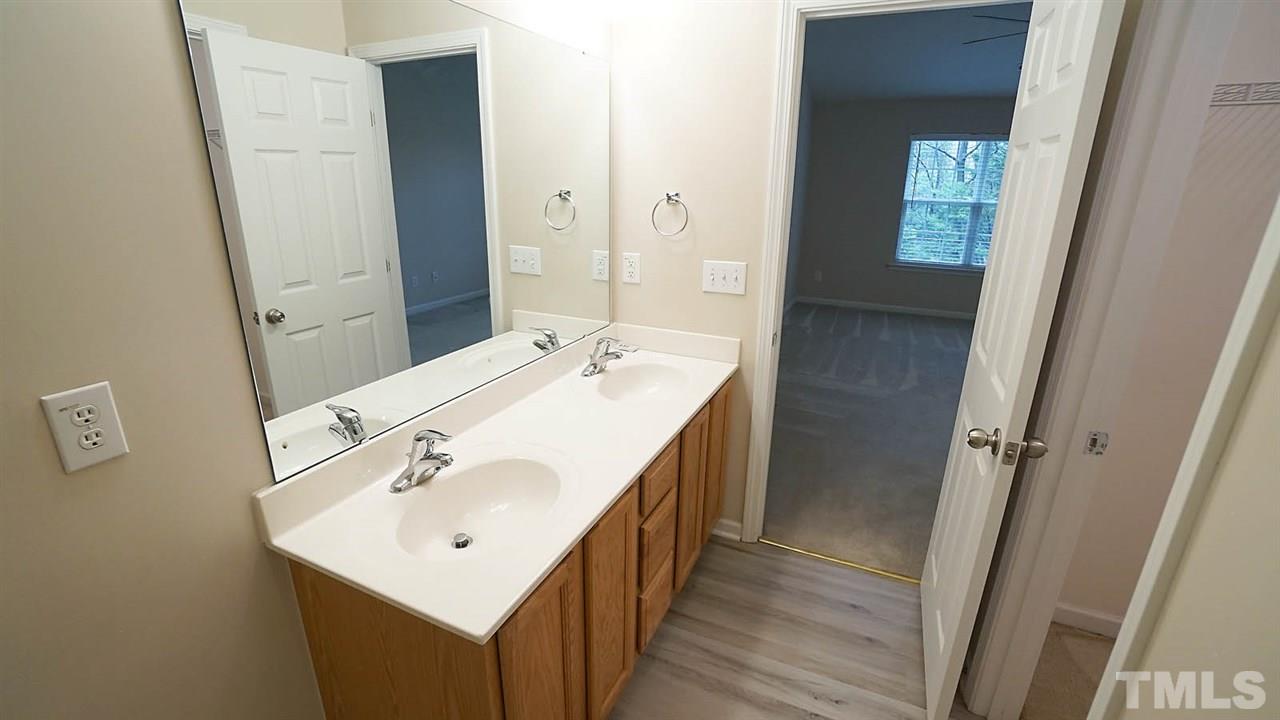 8311 Martello Lane Raleigh, NC 27613 - Photo 22 of 30 a bathroom with a sink a mirror and a toilet