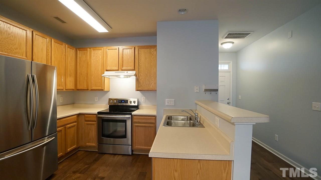 8311 Martello Lane Raleigh, NC 27613 - Photo 6 of 30 a kitchen with a sink a stove and refrigerator