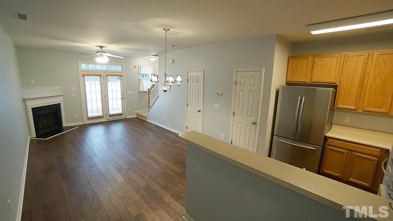 8311 Martello Lane Raleigh, NC 27613 - Photo 8 of 30 an empty room with wooden floor and fireplace